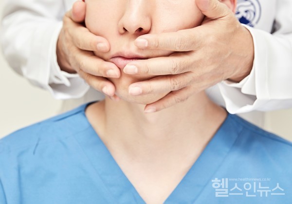 자생한방병원의료진이안면신경마비환자에게안면부추나요법(SJS무저항요법)을실시하고있다.