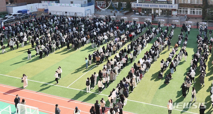 2024학년도 대학수학능력시험을 하루 앞둔 15일 대구 중구 경북대 사대부고 운동장에서 교사가 수험생들에게 수험표를 나눠주고 있다.