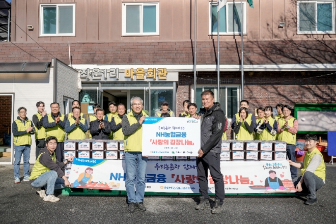NH농협금융지주 이석준 회장과 임직원봉사단은 21일, 강원도 홍천군 영귀미면 소재 왕대추마을에서 「농촌 자매마을과 함께하는 사랑의 김장 나누기」를 실시했다. NH농협금융지주 이석준 회장(사진 왼쪽)과 임직원 봉사단이 왕대추마을 주민들과 전달 행사 후 기념 촬영을 하고 있다. / 사진=NH농협금융 제공