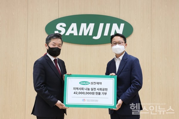 삼진제약진성환이사(좌)양천구자원봉사센터조용국팀장이삼진제약본사에서1일전달식을갖고있다.