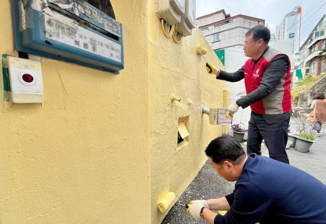 윤수준 롯데건설 영남지사장(오른쪽)과 오은택 남구청장 등 관계자들이 함께 외벽 도장 보수를 하고 있다. / 사진=롯데건설 제공