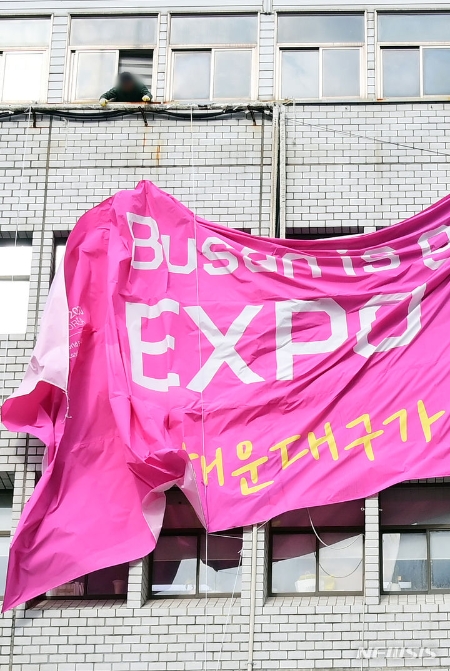 29일 부산 해운대구청 건물 외벽에 내걸린 2030세계박람회 유치 응원 현수막이 철거되고 있다. (사진 = 뉴시스)
