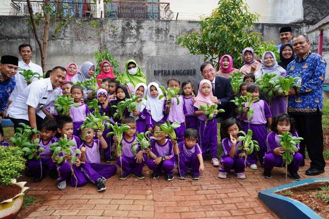 행사에 참석한 한화생명 커뮤니케이션실 홍정표 부사장(2열 우측에서 세번째)과 현지 주민, 아이들이 커뮤니티 활동에 참여한 후 기념촬영을 하며 환하게 웃고 있다. / 사진=한화생명 제공
