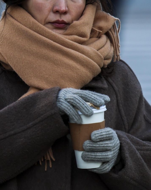 지난 1일 서울 종로구 광화문네거리에서 두꺼운 옷차림을 한 시민이 커피를 쥔 채 이동하고 있는 모습.