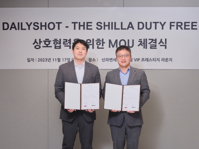 호텔신라 김태호 TR부문장(오른쪽)과 데일리샷 김민욱 대표가 신라면세점 서울점 VIP 라운지에서 전략적 사업 제휴를 위한 업무 협약을 체결한 후 기념 촬영을 하고 있다. / 사진=호텔신라 제공