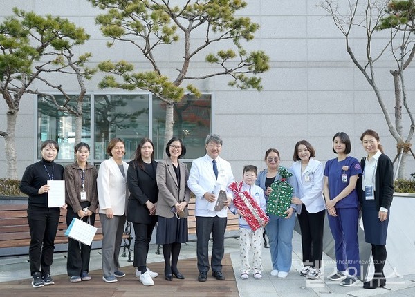 퇴원을앞두고해운대백병원의료진과기념촬영,(좌측6번째부터)김성수원장,환아샤를밭,샤를밭어머니,성형외과이경아교수