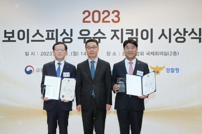 우리은행은 지난 11일 은행연합회 국제회의실에서 개최된 제1회‘보이스피싱 우수 지킴이’시상식에서 중소벤처기업부 장관 표창을 수상했다고 12일 밝혔다. 사진은(왼쪽부터) 우리은행 조병규 은행장, 중소벤처기업부 원영준 소상공인정책실장이 기념촬영을 하고 있는 모습. (사진 = 우리은행 제공)