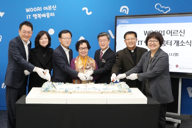 우리은행(은행장 조병규)은 지난 11일 서울 중구 신당동 소재 유락종합사회복지관에서 'WOORI 어르신 행복배움터-중구점' 개소식을 진행했다. 왼쪽부터 장광익 우리은행 브랜드홍보그룹 부행장, 김현미 독거노인종합지원센터장, 조병규 우리은행장, 유락종합사회복지관 어르신 대표, 김길성 중구청장, 정진호 서울가톨릭사회복지회장, 정선희 유락종합사회복지관장이 기념떡케이크 커팅식을 진행하고 있다. / 사진=우리은행 제공