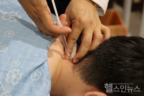 자생한방병원의료진이목통증환자에게약침치료를시행하고있다