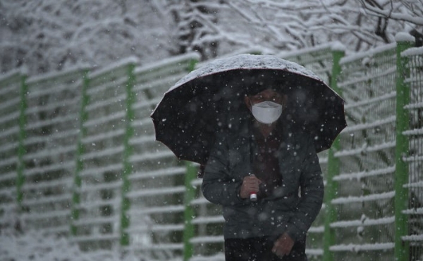 지난 16일 오후 광주 북구 문흥동 맥문동길에서 한 시민이 눈을 맞으며 길을 걷고 있는 모습.