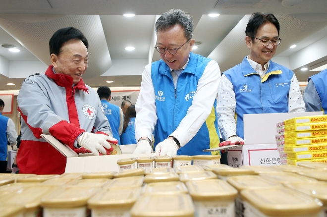 서울시 중구에 위치한 대한적십자사 서울사무소에서 진행된 ‘긴급비상식량세트’ 제작 봉사활동에서 신한은행 정상혁 은행장(가운데)과 대한적십자사 김철수 회장(왼쪽), 신한은행 임원들이 식량세트를 제작하고 있다.