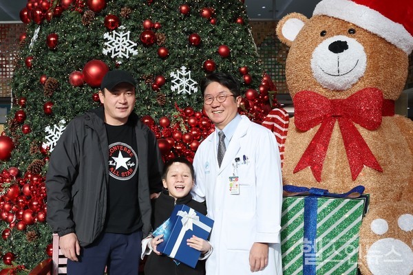 (사진왼쪽부터)알리누르아버지,알리누르와최종우서울아산병원성형외과교수가성공적인치료를기념하며사진촬영을하고있다