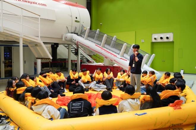 티웨이항공은 지난 19일 서울 강서구 김포공항 화물청사에 위치한 항공훈련센터에서 강원도 속초시 설온중학교 3학년 학생 30명을 초청해, 학생들의 항공 진로 탐색과 안전의식 제고를 위한 교육 기부활동을 진행했다고 21일 밝혔다. 사진은 지난 19일 티웨이항공 훈련센터에서 객실 승무원 체험 활동에 참여한 속초 설온중학교 학생들이 래프트 탑승과 캐노피 설치 훈련을 체험하는 모습. (사진 = 티웨이항공 제공)