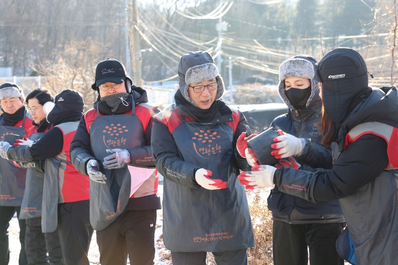 롯데건설 박현철 부회장(오른쪽 세번째)괴 배우 정애리(오른쪽 두번째)가 임직원들과 함께 연탄을 나르고 있다.(롯데건설 제공)