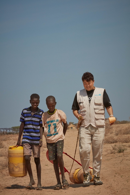 케냐 투르카나 지역을 방문한 김호중이 마실 물을 구하러 가는 샤드락(가운데)과 친구를 따라 길을 나서고 있다. (사진제공=유니세프 한국위원회)