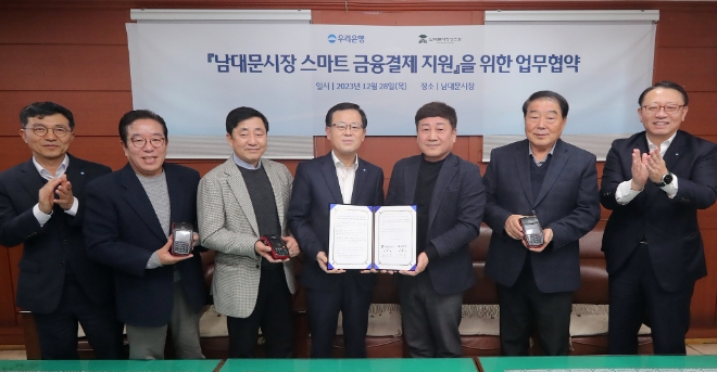 (왼쪽부터) 전성찬 우리은행 용산영업본부장, 성하준 상인회 부회장, 최일환 상인회 수석부회장, 조병규 우리은행장, 문남엽 상인회 회장, 박영철 서울남대문시장(주) 대표이사, 정진완 우리은행 중소기업그룹장이 기념 촬영을 하고 있다. / 사진=우리은행 제공