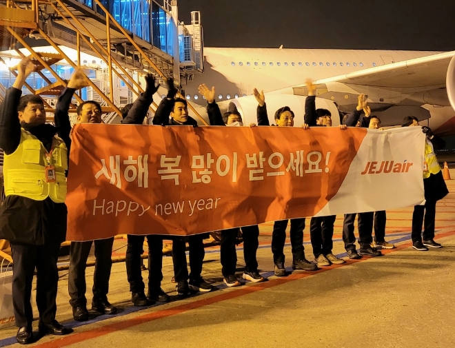 김이배 제주항공 대표이사(왼쪽에서 여섯 번째)와 임직원들이 인천국제공항에서 새해 첫 출발편탑승객들에게 인사를 하고 있다. / 사진=제주항공 제공