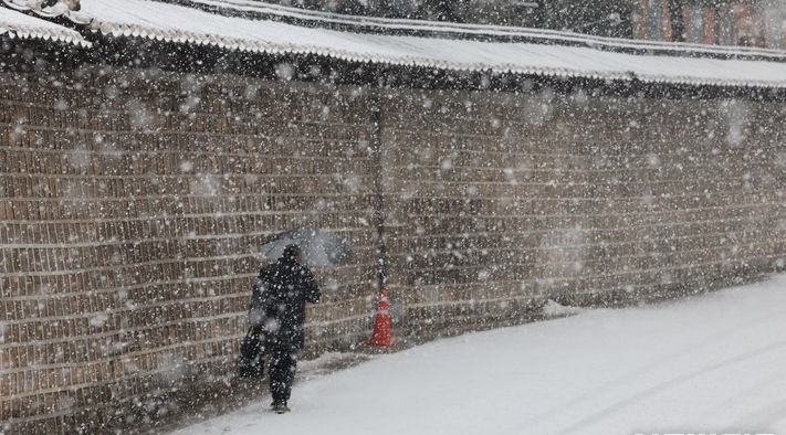 지난달 30일 서울 종로구 세종대로 일대에서 한 시민이 우산을 쓰고 지나가고 있는 모습.