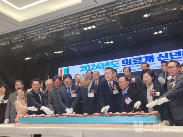 2024의료계신년하례회에서참석자들이함께떡케이크를썰고있다.