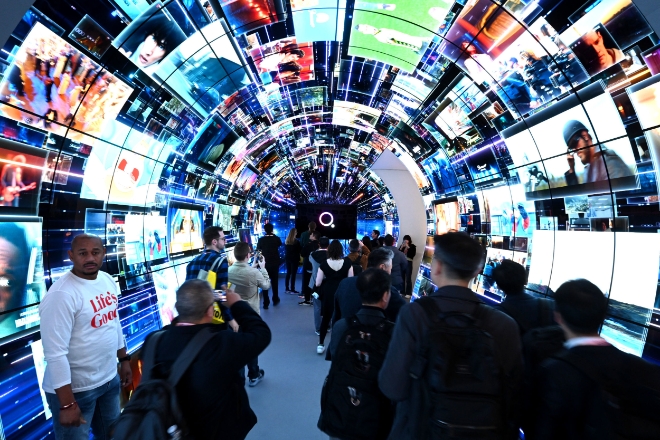 LG전자는 CES 2024에서 글로벌 OTT 파트너사들과 함께 구축한 아치형 터널 구조 webOS 콘텐츠 체험 공간을 선보였다고 10일 밝혔다. 사진은 CES 2024 LG전자 부스를 찾은 관람객들이 스마트 TV 플랫폼 'webOS'의 다양한 콘텐츠들을 체험하는 모습. (사진 = LG전자 제공)