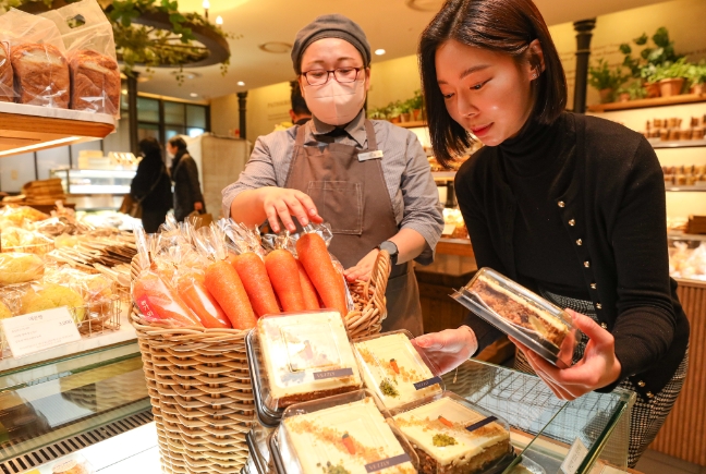 고객이 현대그린푸드가 운영하는 프리미엄 베이커리 브랜드 ‘베즐리(VEZZLY)’ 무역센터점에서 제주산 당근이 사용된 '제주 당근 케이크'를 살펴보는 모습