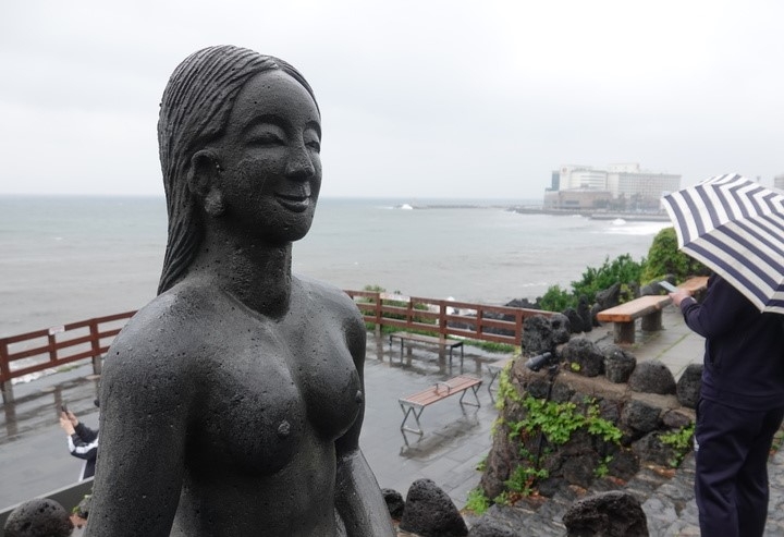 제주시 용두암에서 우산을 쓴 관광객이 바다를 구경하고 있다.