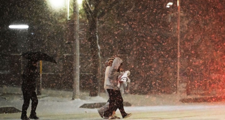 광주지역에 대설주의보가 내려진 22일 오후 광주 서구 서부경찰서 주변 횡단보도에서 시민들이 눈을 맞으며 걸음을 재촉하고 있다.