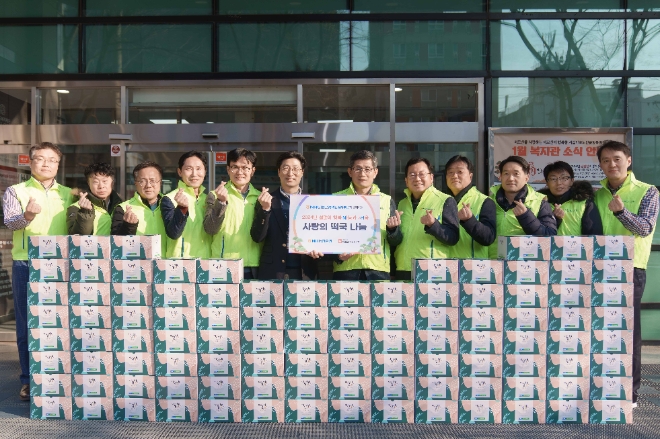 김길수(오른쪽 여섯 번째)NH농협은행 여신심사부분 부행장, 김욱(오른쪽 일곱 번째) 마포시립복지관장을 비롯한 참석자들이 26일 서울 마포구 마포노인종합복지관에서 열린 설맞이 사랑의 떡국세트 나눔 행사에서 기념촬영을 하고 있다. / 사진=NH농협은행 제공