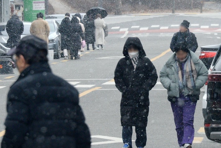 쌀쌀한 겨울 날씨가 이어지고 있는 23일 전북 전주시 전주중앙시장 일대에서 시민들이 차가운 바람과 눈을 맞으며 길을 지나고 있다.