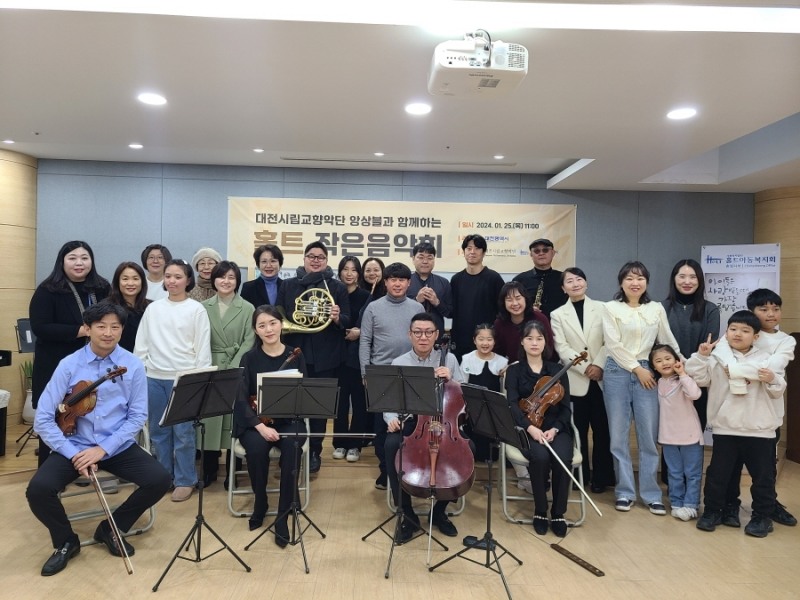 △사진설명=홀트아동복지회 충청지부 가족들과 대전시립교향악단 앙상블 단원들이 단체사진을 찍고 있다.