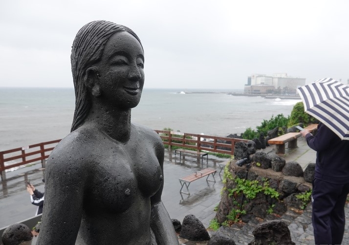 제주시 용두암에서 우산을 쓴 관광객이 바다를 바라보고 있다.