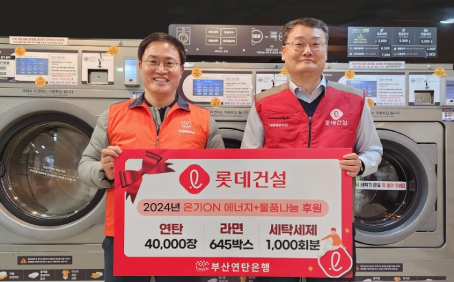 윤수준 롯데건설 영남지사장(오른쪽)과 강정칠 부산연탄은행 대표가 세탁세제 및 연탄과 라면 기증판 전달식에 참여하고 있다. / 사진=롯데건설 제공