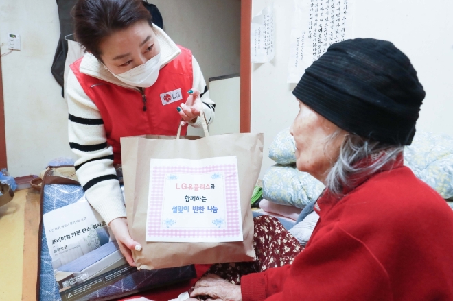 LG유플러스는 설 명절을 맞아 용산구 후암동 쪽방촌 독거 어르신들에게 반찬나눔 봉사활동을 진행했다고 6일 밝혔다. 사진은 전날 오전 서울 용산구 후암동 중식당 ‘유원’에서 LG유플러스 임직원들이 독거어르신들에게 전달할 반찬을 담고 있는 모습. (2)LG유플러스 직원이 반찬을 어르신에게 전달하는 모습.