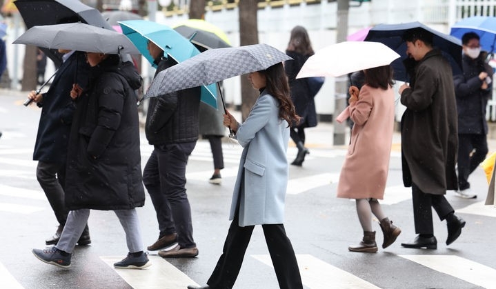 11일 오전 서울 종로구 한 거리에서 우산을 쓴 시민들이 발걸음을 재촉하고 있다.