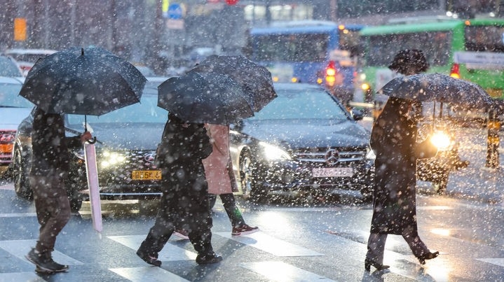 서울 중구의 한 거리에서 시민들이 눈을 맞으며 발걸음을 옮기고 있다.