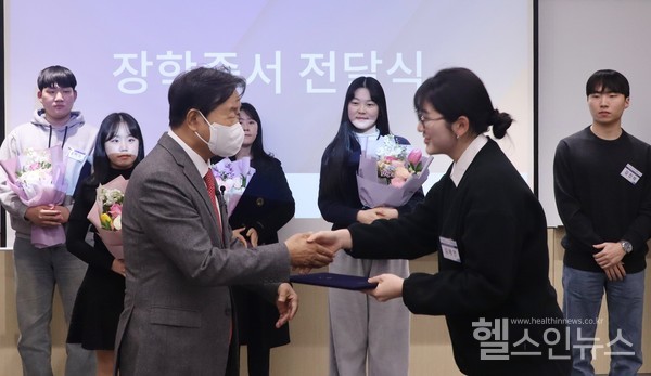 자생한방병원설립자신준식박사가‘자생신준식장학금’장학생에게장학금과장학증서를전달하고있다