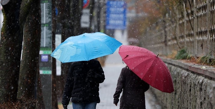 사진은 전국 대부분 지역에 비나 눈이 내린 지난 15일 서울 서초구 한 거리에서 시민들이 우산을 쓰고 이동하는 모습.