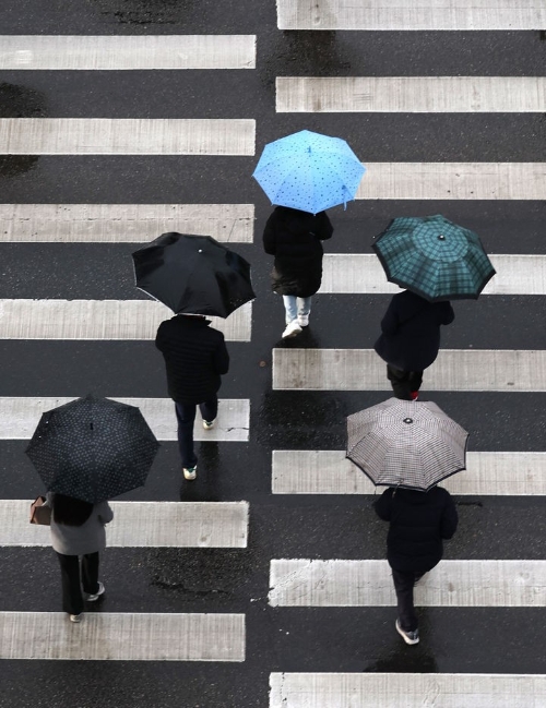겨울비가 내리는 지난 15일 오전 인천 남동구 가천길병원 인근 횡단보도에서 시민들이 우산을 쓰고 걸어가고 있다.
