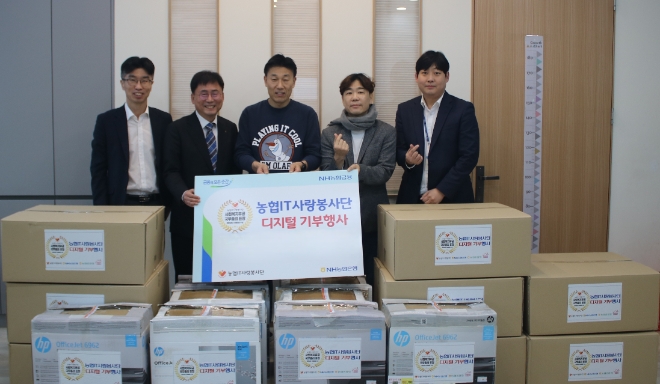 서초구 관내 지역 아동센터(가운데 우면지역아동센터장 김기철)에서 NH농협은행 IT사랑봉사단장(센터장 오른쪽 서을구 단장)과 황재현 IT 부행장(센터장 왼쪽)이 기념 촬영을 하고 있다. / 사진=NH농협은행 제공