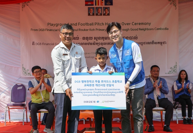 (왼쪽부터) 캄보디아 뚜올로까꼬스 초등학교 Mr. Rath 교장 선생님과 초등학생, DGB금융지주 그룹지속가능경영총괄 성태문 전무가 교육환경개선사업 전달식 후 기념 촬영을 하고 있다