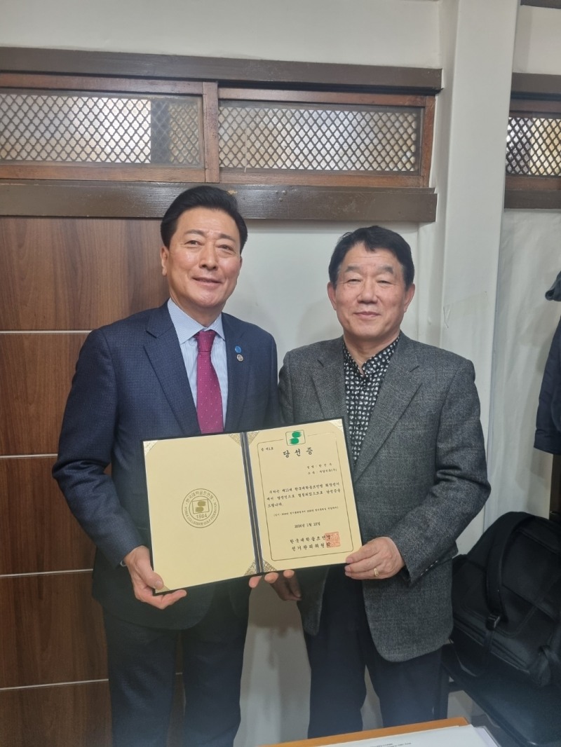 한국대학골프연맹 회장 당선증을 받는 한진우 회장(왼쪽).