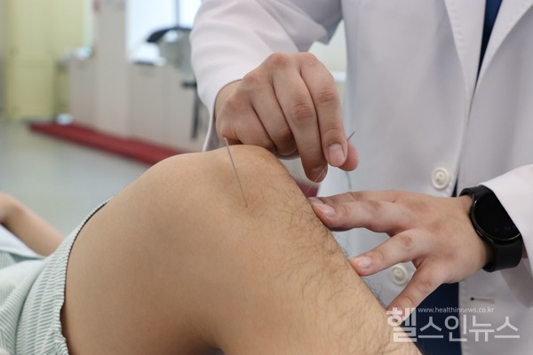 자생한방병원의료진이환자의무릎관절에침치료를실시하고있다