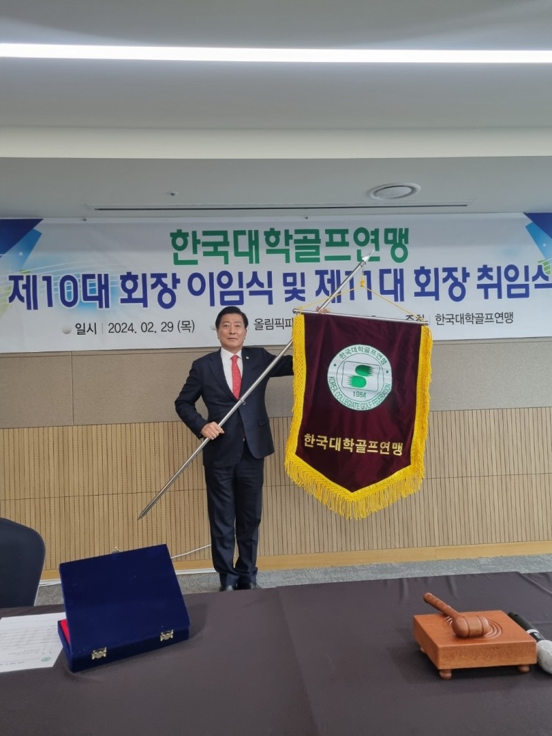 한진우 한국대학골프연맹 회장이 취임식에서 연맹기를 들고 있다. 