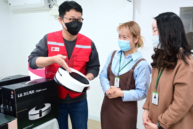 LG전자 임직원으로 구성된 '라이프스굿 봉사단'이 대한사회복지회 암사재활원 관계자에게 물걸레 전용 로봇청소기 ‘코드제로 오브제컬렉션 M9’ 사용법을 안내하고 있다.