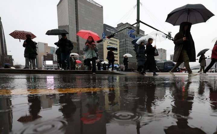 전국 대부분 지역이 흐리고 비가 내리는 21일 오전 서울 종로구 광화문사거리에서 시민들이 우산을 쓰고 출근길 발걸음을 재촉하고 있다.