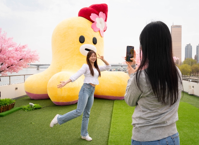 LG유플러스는 지난달 30일부터 오는 14일까지 여의도 일대에서 자사 대표 캐릭터 ‘무너’를 소개하는 초대형 팝업 전시 ‘무너의 봄 피크닉’을 진행한다고 1일 밝혔다. 사진은 LG유플러스 모델이 무너 조형물 포토존에서 기념사진을 촬영하는 모습. (사진 = LG유플러스 제공)