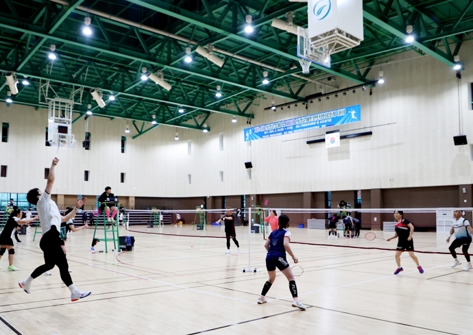 배드민턴 생활체육대회에서 선수들이 네트를 사이에 두고 경기를 하고 모습.