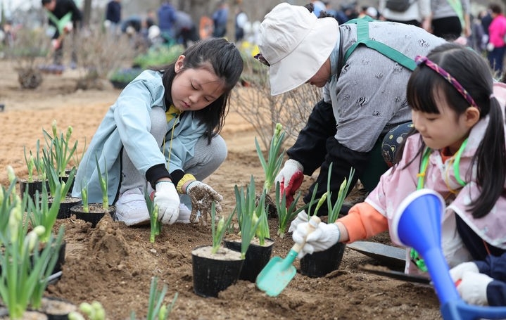 서울 강동구 암사역사공원 일대에서 열린 제79회 식목일 기념 동행매력 정원도시 서울 만들기 행사에서 어린이들이 꽃을 심고 있다.