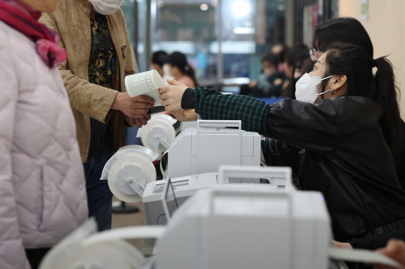 제22대 국회의원선거 사전투표가 시작된 5일 오전 서울 서초구 내곡열린문화센터에 마련된 사전투표소에서 한 유권자가 투표용지를 받고 있다. 출처=연합뉴스