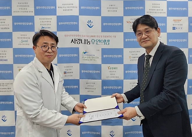 광주이주민건강센터 ‘사랑나눔 후원의밤’에서 온라인팜 약국 영업부 임선 이사(오른쪽)가 최창옥 센터 등기이사에게 제이브이엠 의약품 자동 조제기 기증서를 전달하고 있다.